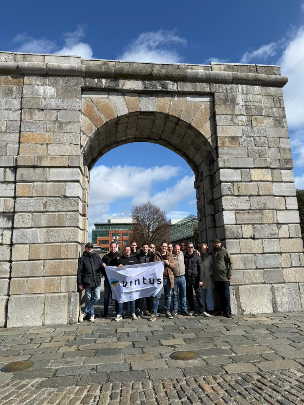 Het Vintus-team met de vlag onder de arch in Dublin